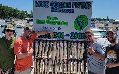 Four happy anglers displaying a plentiful catch of fish after a successful day with More Gooder Fishing Charters on Lake Erie, showcasing the charter's contact information, taken on July 19, 2022.
